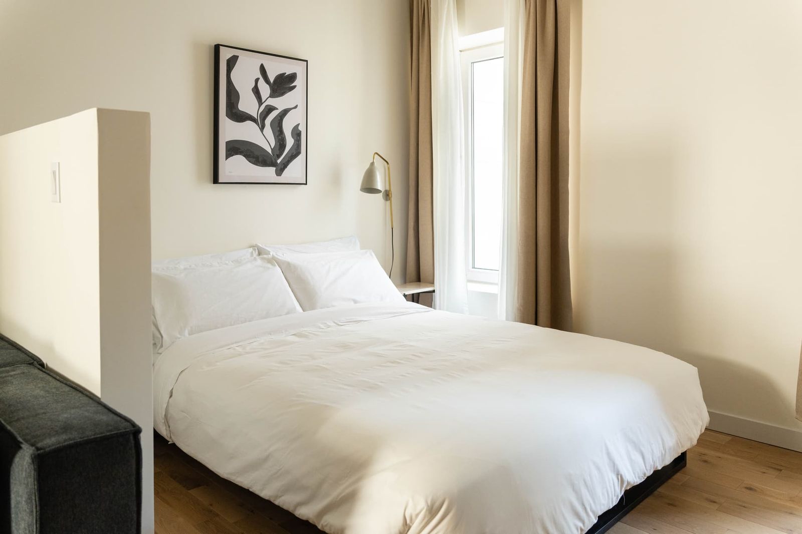 Chambre lumineuse au lit fait avec des draps blancs